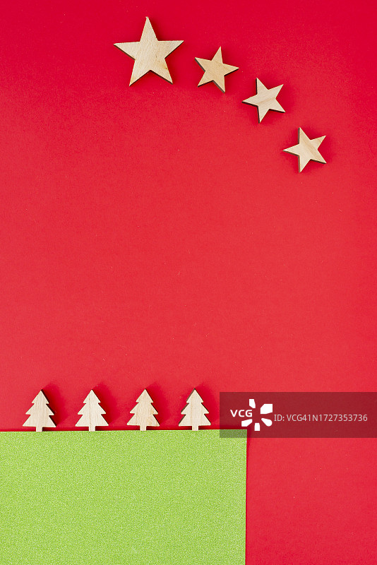 用木制树和星星制成的另类圣诞贺卡，红色背景图片素材