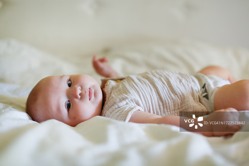 纯真时刻：捕捉一个胖乎乎的婴儿在卧室里平静地仰卧的温柔宁静图片素材