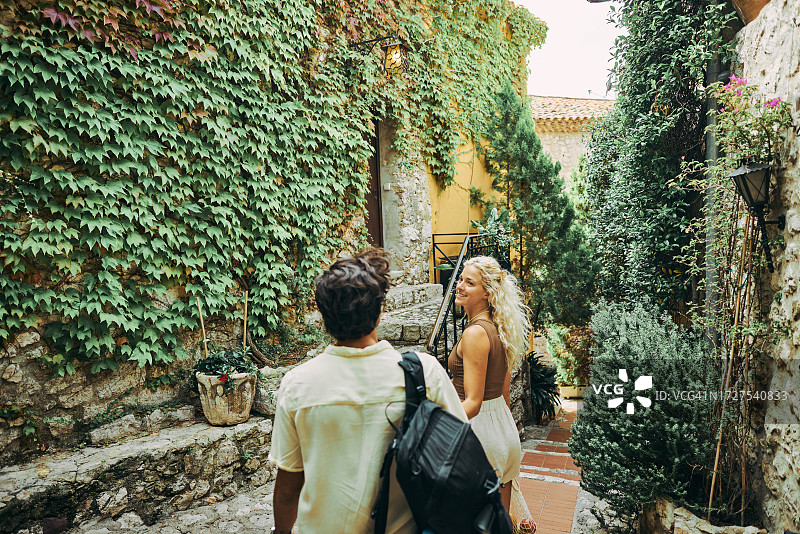 快乐的千禧一代夫妇在法国南部埃兹的历史村庄度假图片素材