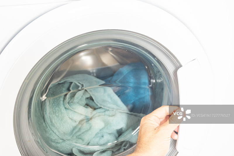 男人在洗衣服前关上洗衣机图片素材