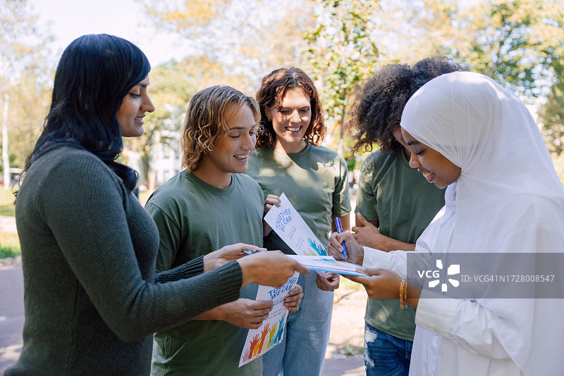 志愿者让人们签署他们的筹款和捐赠活动图片素材