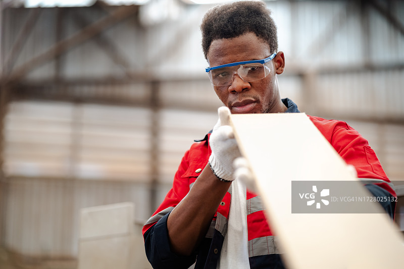 托盘厂的工人们盯着木板的曲线，检查零件的质量图片素材