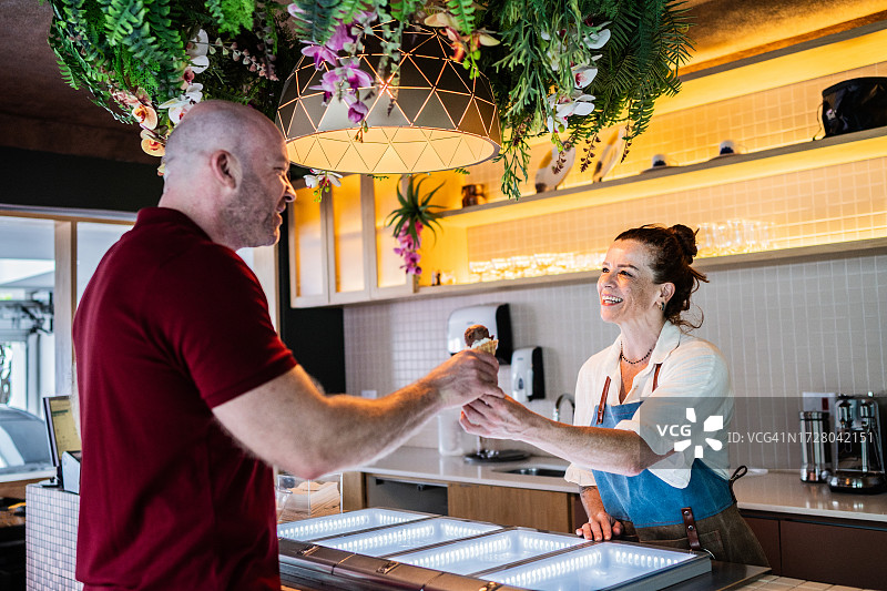 冰淇淋店员为顾客提供冰淇淋图片素材