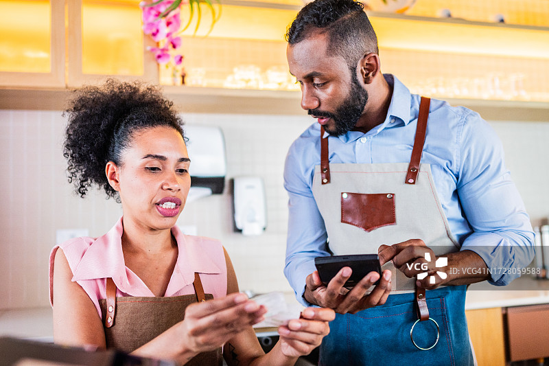 经理在冰淇淋店计算并与员工交谈图片素材