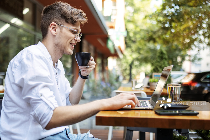 沉浸在笔记本电脑工作的年轻男人图片素材