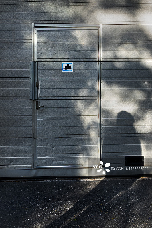 男人影子映在关闭的金属门上图片素材