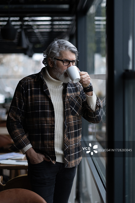 男人在咖啡馆放松，手持咖啡杯图片素材