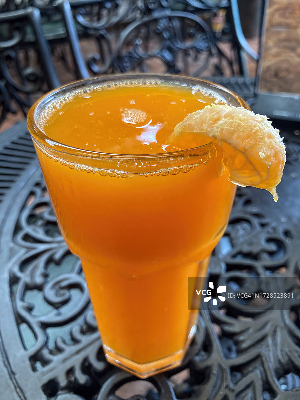 橘子汁——铸铁咖啡桌上新鲜的橘子汁图片素材