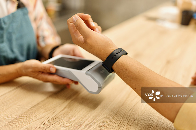人们使用智能手表进行支付的特写图片素材