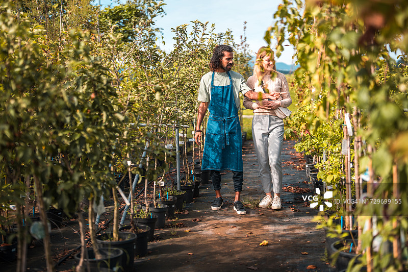 园丁在园艺中心指导白人女性图片素材