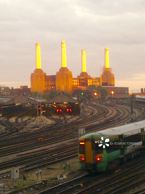 黄昏时分翻新前的巴特西发电站，前景是火车和铁轨。2010年6月伦敦标志性发电站图片素材