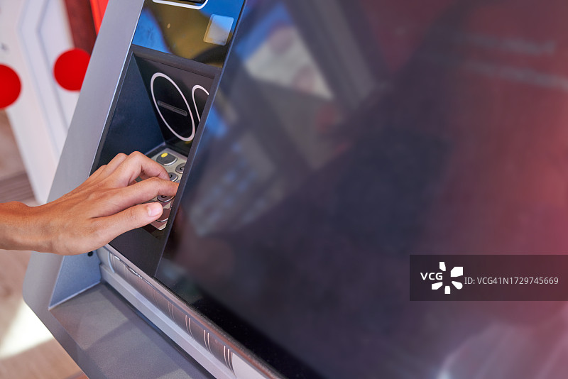 在城市里使用自动取款机的年轻日本女子图片素材