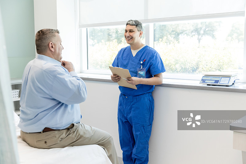 快乐的男急诊科医生看男病人图片素材