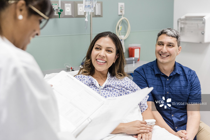 医生分享好消息时微笑情侣的肩上视角图片素材