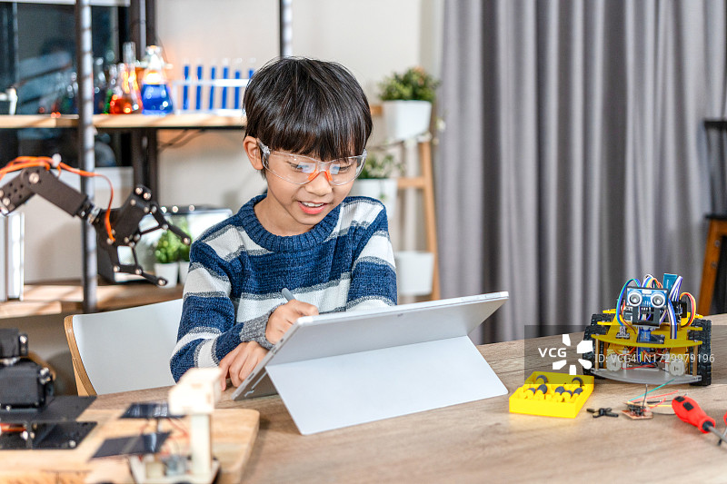 亚洲青少年在家制作玩具汽车作业项目，机器人编程和STEM教育理念图片素材