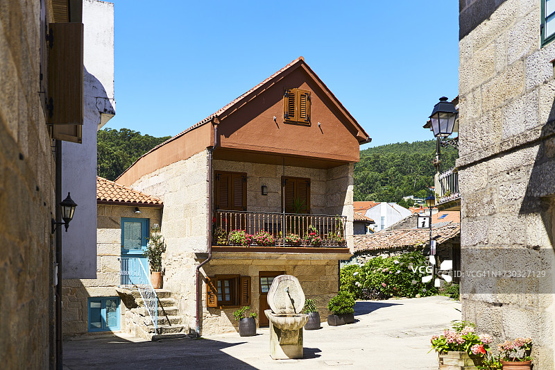 城镇房屋外街道中央的混凝土喷泉，正面视角图片素材