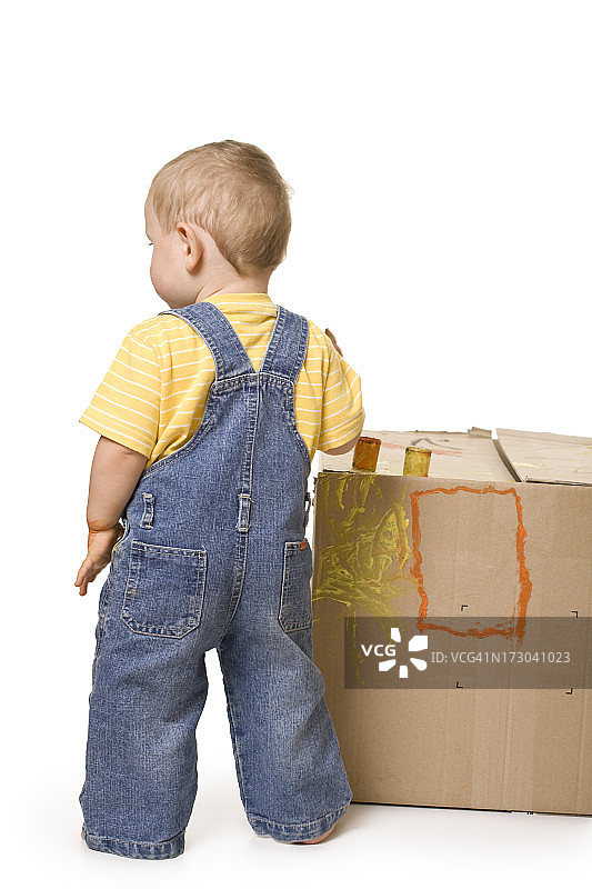 正在粉刷盒子的孩子背影图片素材