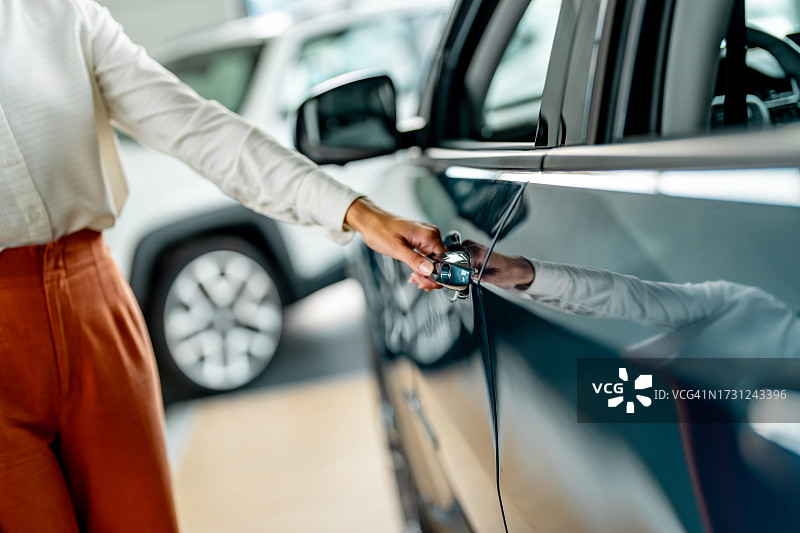 年轻女子伸手打开车门图片素材