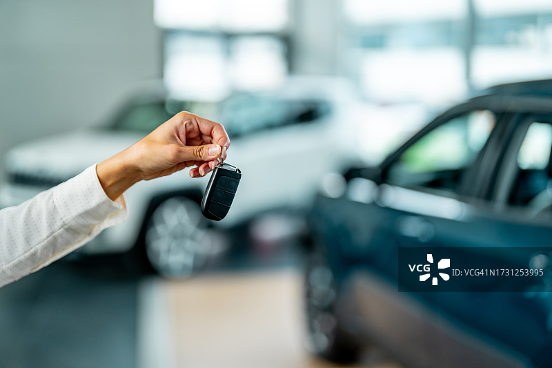汽车交付演示：女子展示智能车钥匙图片素材