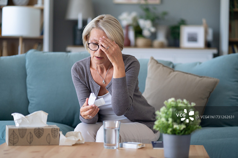 头痛的女人正在阅读药丸说明书图片素材