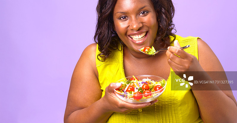 快乐的胖女人在吃沙拉图片素材