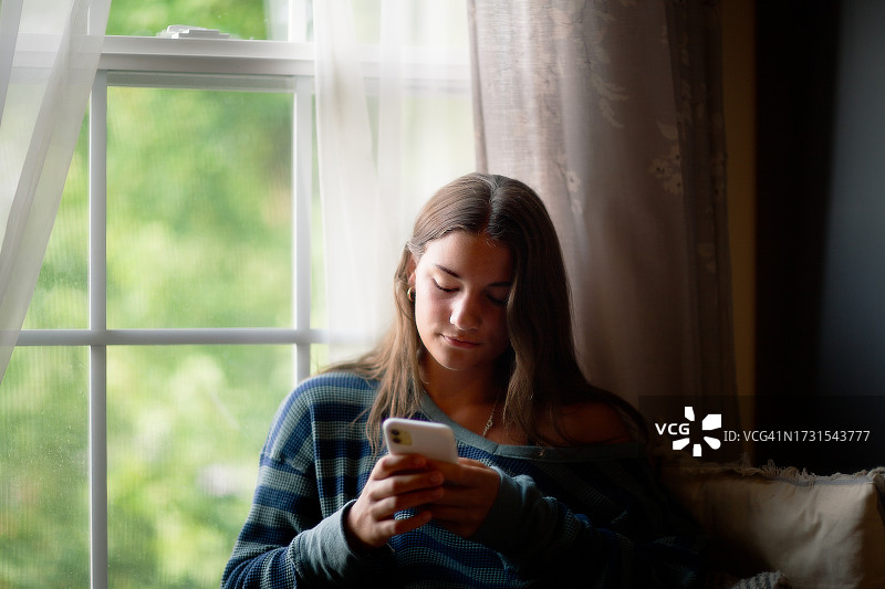 少女在家使用手机图片素材
