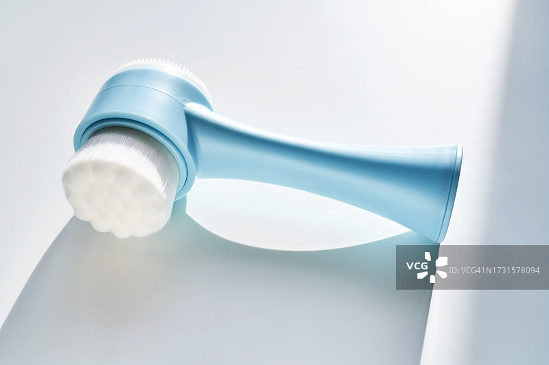 白色背景下带阴影的蓝色洁面刷图片素材