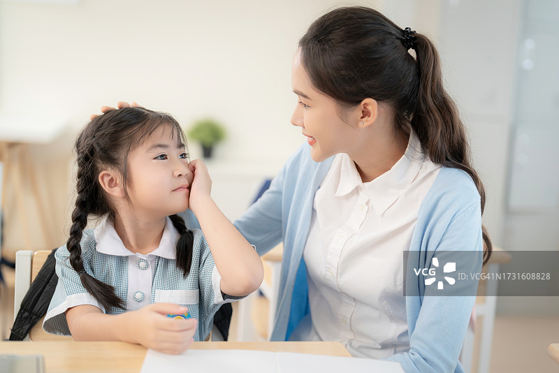 教室里表达悲伤和哭泣的亚洲学龄前儿童图片素材