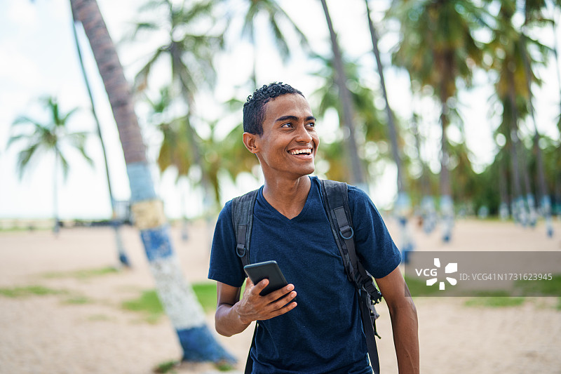 在哥伦比亚里奥阿查马雷贡海滩上散步的拉丁美洲男游客图片素材