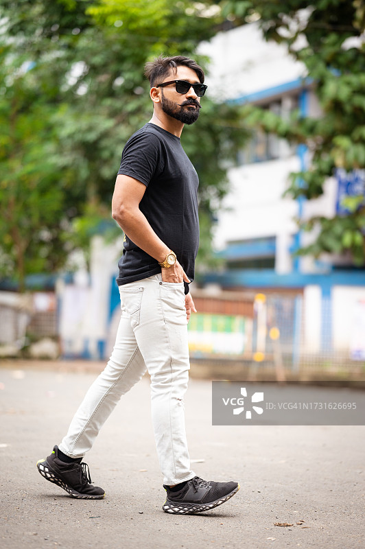 走在城市街道上的年轻时尚男人图片素材