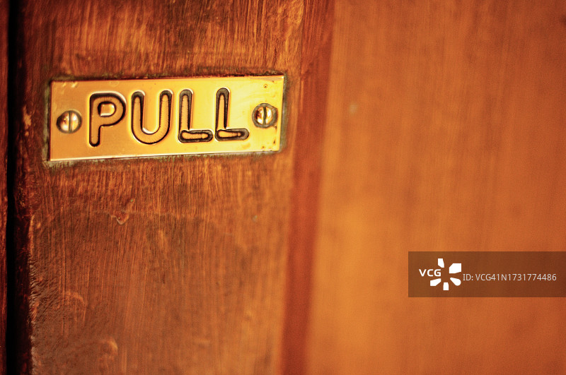 旧木门上的金色拉动标志图片素材
