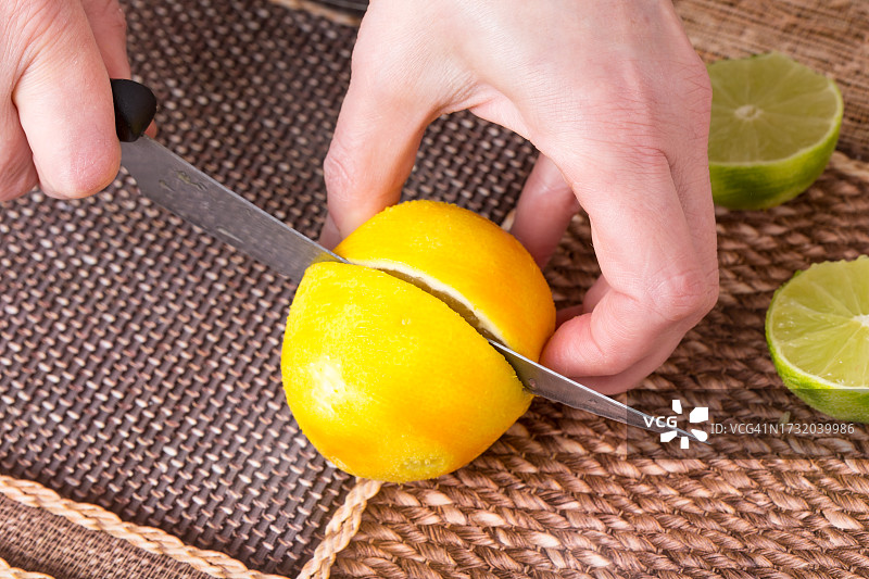 裁剪的手在木板上切柠檬图片素材