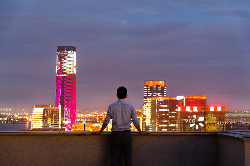 在屋顶上看城市景观的商人图片素材
