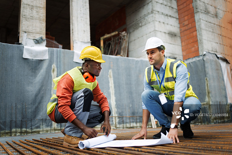 建筑工人在建筑工地分析蓝图图片素材