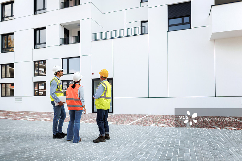 建筑检查员在新建筑物前协同工作图片素材