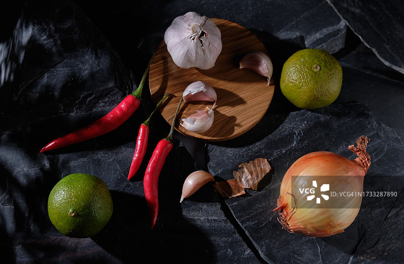 桌子上的大蒜、红辣椒、洋葱和酸橙图片素材