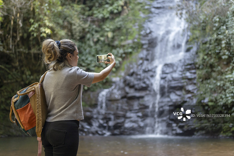 女人拍摄瀑布图片素材
