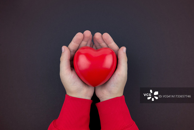 女子双手在黑色背景前做出心形图片素材