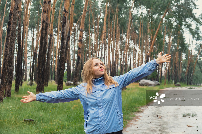 在森林中，站在树前伸开双臂的女人图片素材