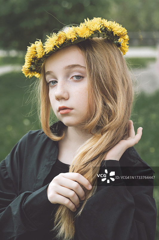 站在田野上戴着鲜花的女孩肖像图片素材