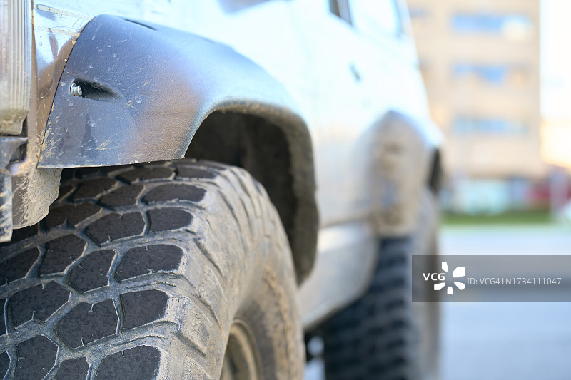 停在城市街道上的4x4汽车的脏污轮胎图案（低角度）图片素材