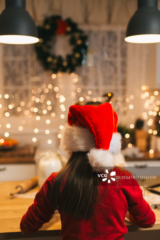 女孩在圣诞节期间制作圣诞饼干的背影图片素材