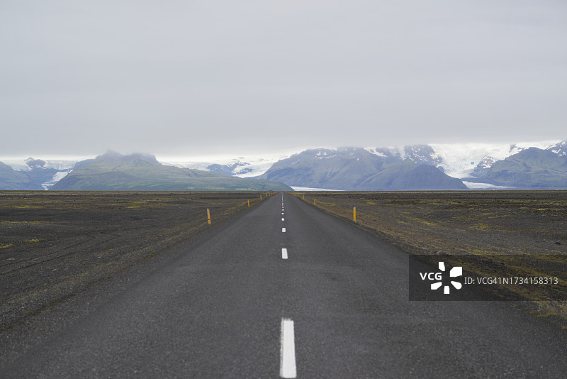 空旷的道路通向群山，背对天空图片素材