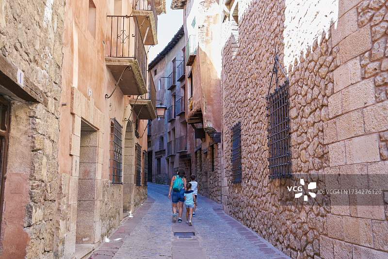成年女性在家庭周末带着孩子走在小巷里图片素材