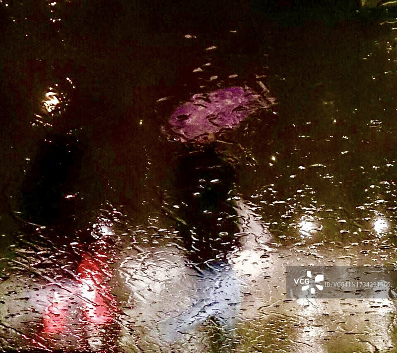 在夜雨中行走的人们图片素材