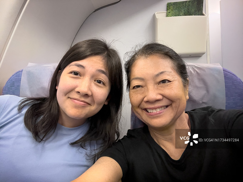 不同种族的女儿和亚洲老母亲在飞机上自拍图片素材