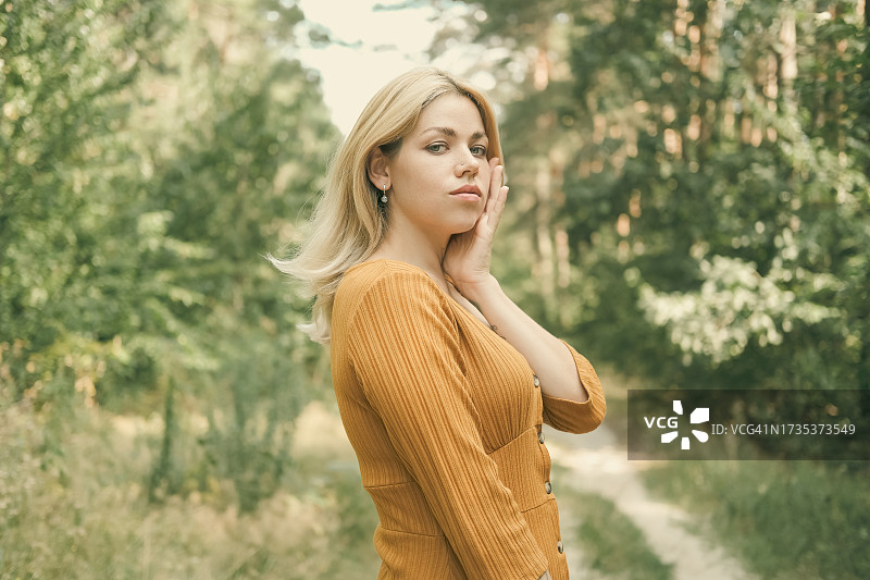 在夏日森林小路上的年轻女人图片素材