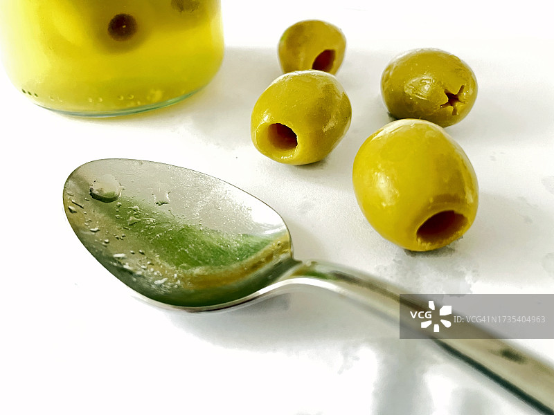 柜台上放着勺子和罐子的橄榄图片素材