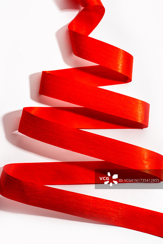 白色背景上用红色缎带制作的圣诞树假日背景图片素材