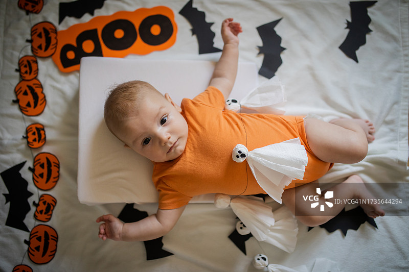 万圣节穿橙色连体衣的可爱男婴图片素材